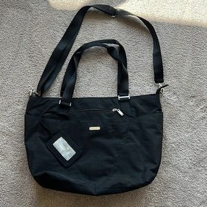Baggallini black tote- multiple pockets. Trolley sleeve. Used once. No stains.